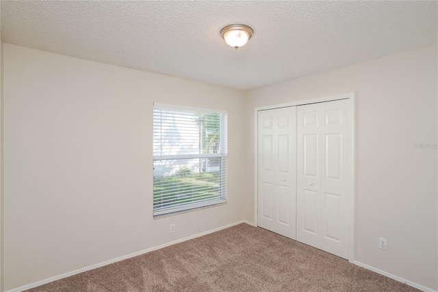 11212 3rd Ave E, Bradenton, FL 34212 - unfurnished bedroom with carpet, a closet, a textured ceiling, and baseboards