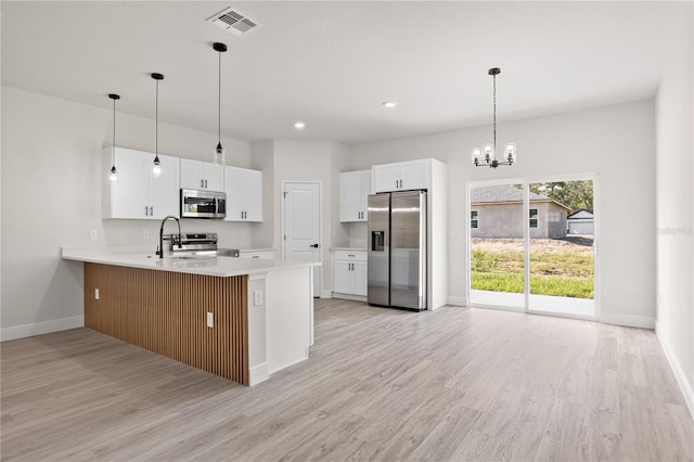 3749 SW 131st St, Ocala, FL 34473 - kitchen featuring stainless steel appliances, light wood finished floors, baseboards, a peninsula, and a chandelier