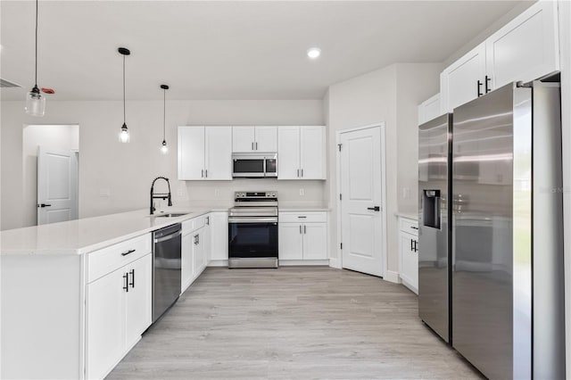 3749 SW 131st St, Ocala, FL 34473 - kitchen with stainless steel appliances, a sink, a peninsula, light wood finished floors, and white cabinets