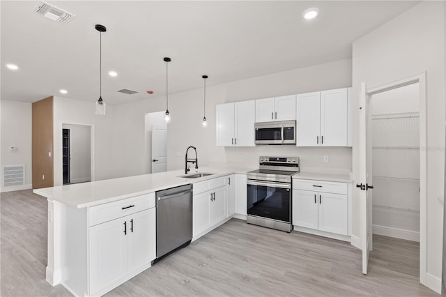 3749 SW 131st St, Ocala, FL 34473 - kitchen with appliances with stainless steel finishes, a sink, a peninsula, light wood finished floors, and white cabinets
