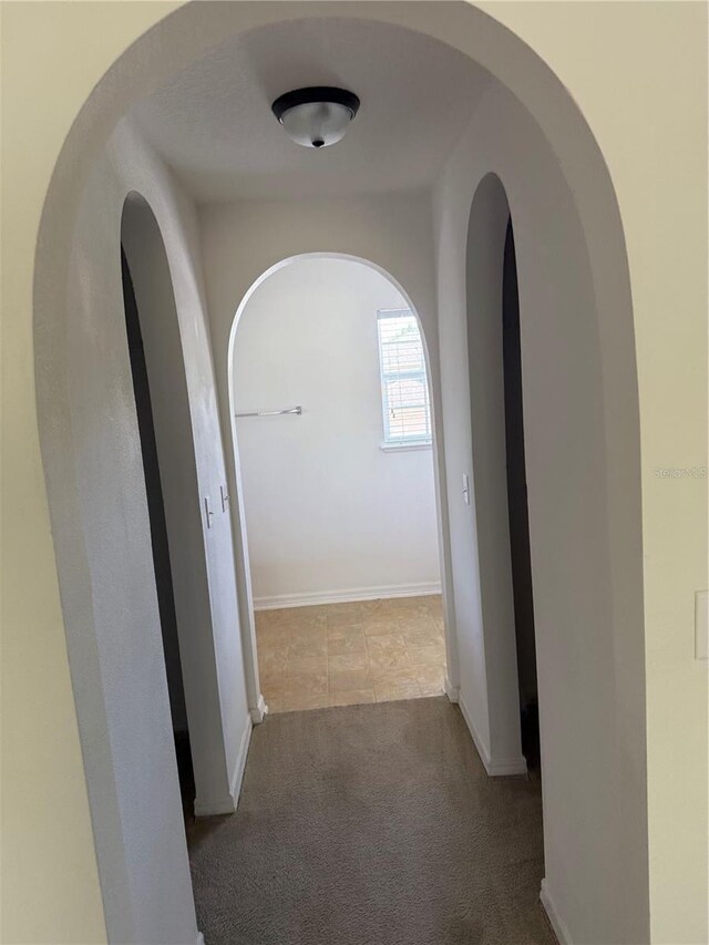 436 Hammerstone Ave, Haines City, FL 33844 - hallway with carpet floors, arched walkways, and baseboards