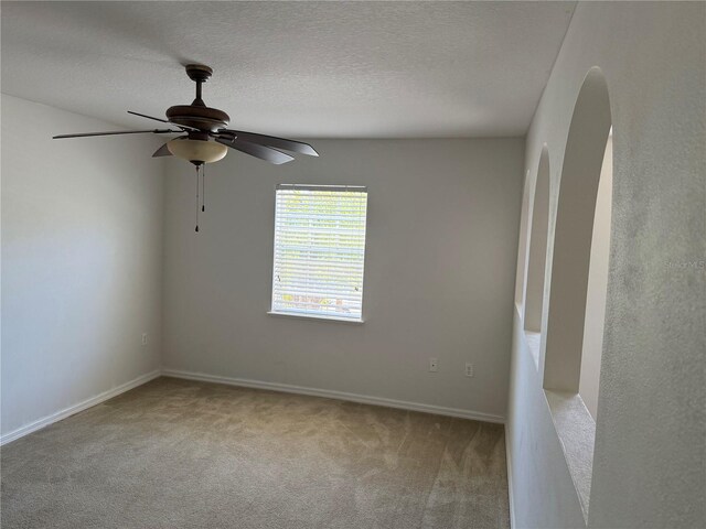 436 Hammerstone Ave, Haines City, FL 33844 - carpeted empty room featuring a ceiling fan, baseboards, arched walkways, and a textured ceiling