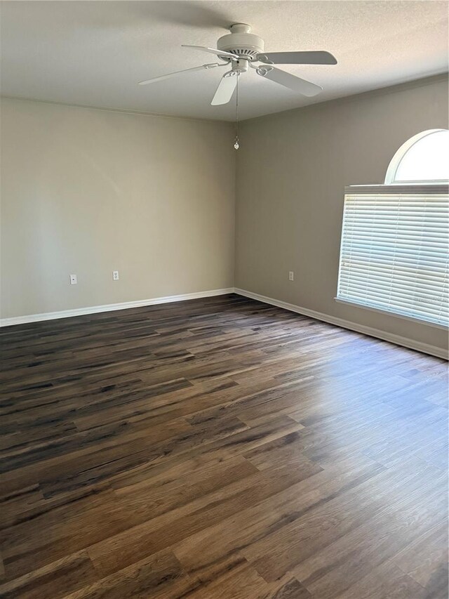 436 Hammerstone Ave, Haines City, FL 33844 - empty room with dark wood-style flooring, a ceiling fan, and baseboards