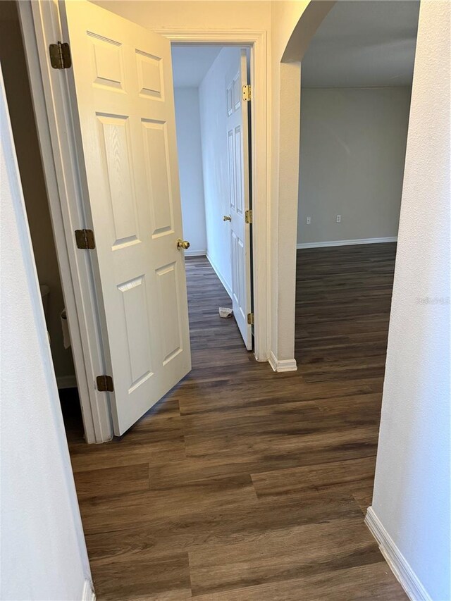 436 Hammerstone Ave, Haines City, FL 33844 - corridor with arched walkways, baseboards, and dark wood-style floors