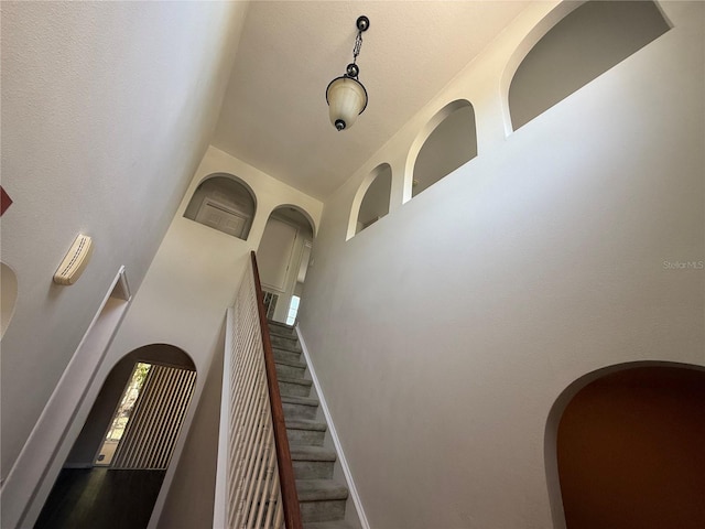 436 Hammerstone Ave, Haines City, FL 33844 - staircase with a towering ceiling, baseboards, and arched walkways