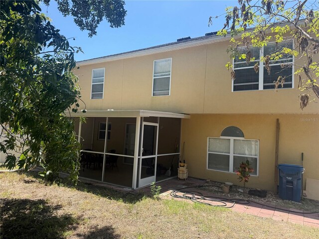 436 Hammerstone Ave, Haines City, FL 33844 - rear view of house with a sunroom and stucco siding