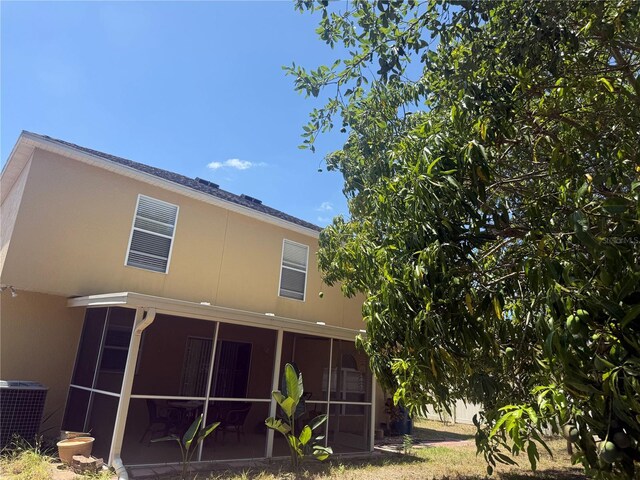 436 Hammerstone Ave, Haines City, FL 33844 - rear view of property with a sunroom, cooling unit, and stucco siding