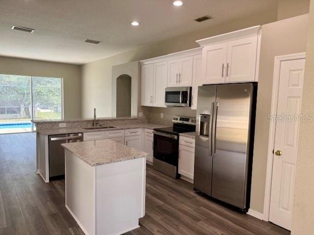 307 Dalton Ct, Davenport, FL 33897 - kitchen featuring stainless steel appliances, a sink, dark wood-style floors, light stone counters, and recessed lighting