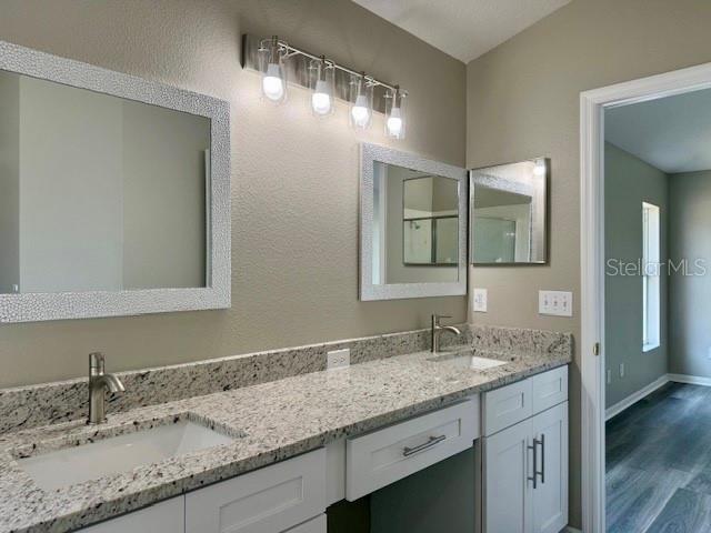 307 Dalton Ct, Davenport, FL 33897 - full bath featuring double vanity, wood finished floors, and baseboards