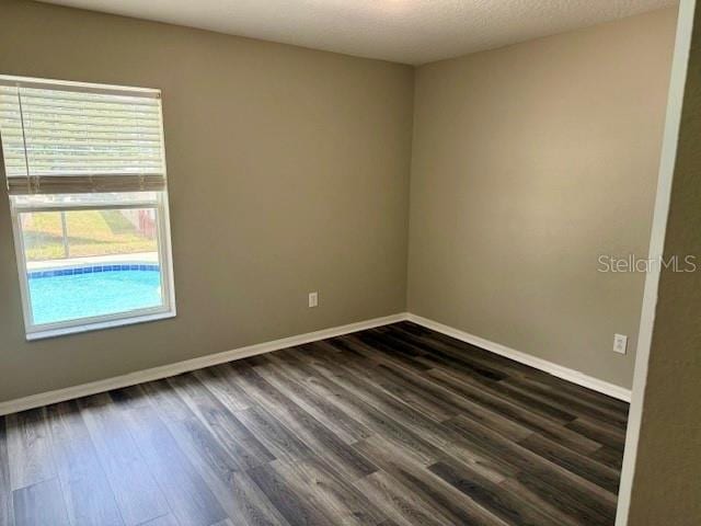 307 Dalton Ct, Davenport, FL 33897 - unfurnished room featuring dark wood-type flooring and baseboards