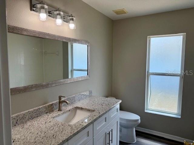 307 Dalton Ct, Davenport, FL 33897 - bathroom with vanity, toilet, baseboards, and wood finished floors