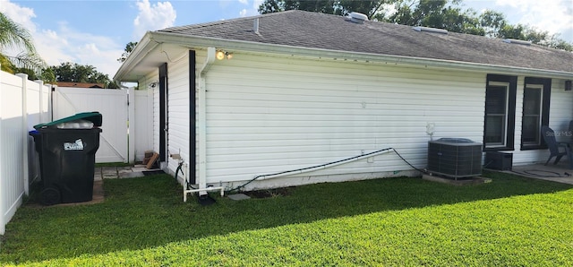 8767 Grandee Dr, Orlando, FL 32829 - view of side of home with a shingled roof and a central AC unit