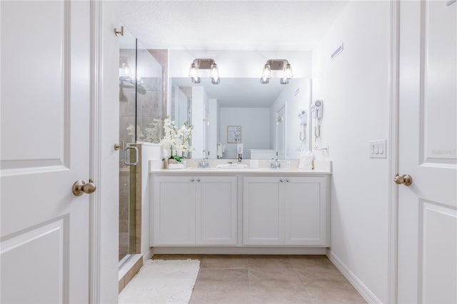 665 Longboat Dr, Davenport, FL 33896 - bathroom featuring double vanity, a stall shower, tile patterned flooring, and baseboards