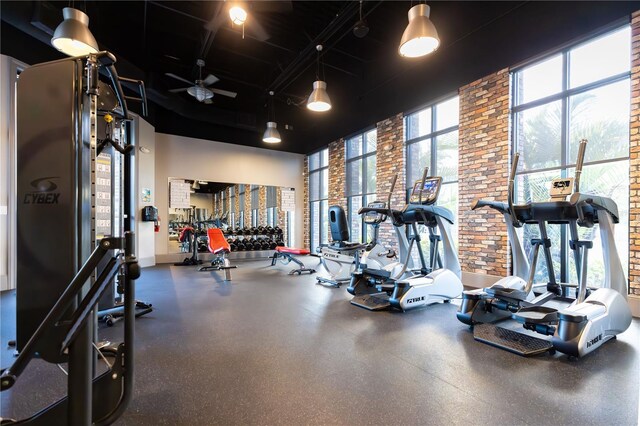665 Longboat Dr, Davenport, FL 33896 - gym with a towering ceiling, brick wall, and baseboards