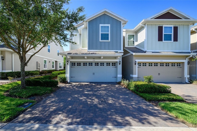 978 E 10th St, Apopka, FL 32703 - view of front of property featuring board and batten siding, an attached garage, and decorative driveway