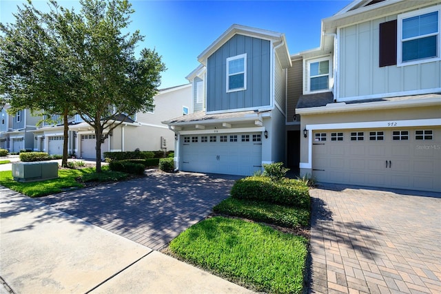 978 E 10th St, Apopka, FL 32703 - view of property featuring board and batten siding, a garage, and decorative driveway