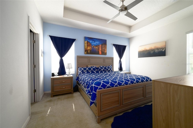 978 E 10th St, Apopka, FL 32703 - bedroom with light colored carpet, a tray ceiling, a ceiling fan, and baseboards