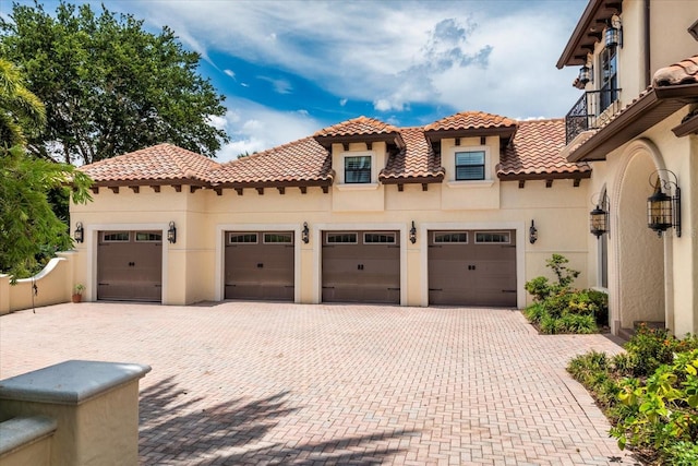 9253 Tibet Pointe Cir, Windermere, FL 34786 - mediterranean / spanish-style home with stucco siding, decorative driveway, a garage, and a tile roof