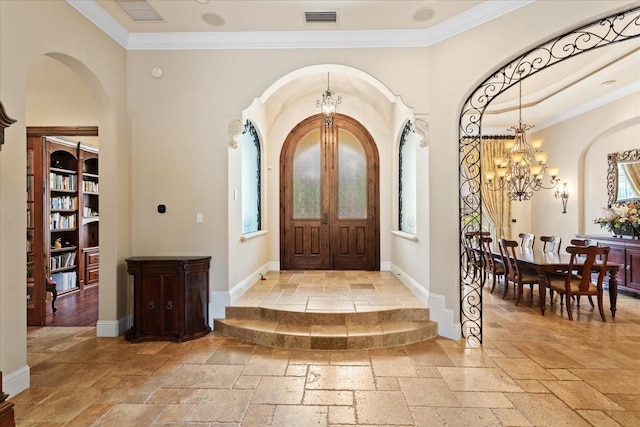 9253 Tibet Pointe Cir, Windermere, FL 34786 - foyer featuring stone tile floors, a chandelier, arched walkways, crown molding, and plenty of natural light