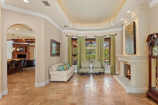 9253 Tibet Pointe Cir, Windermere, FL 34786 - living area with ceiling fan, stone tile floors, arched walkways, crown molding, and a premium fireplace