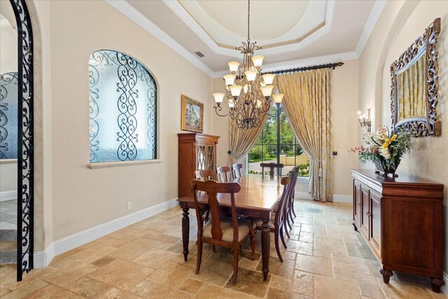 9253 Tibet Pointe Cir, Windermere, FL 34786 - dining area with stone tile floors, a chandelier, a raised ceiling, crown molding, and baseboards