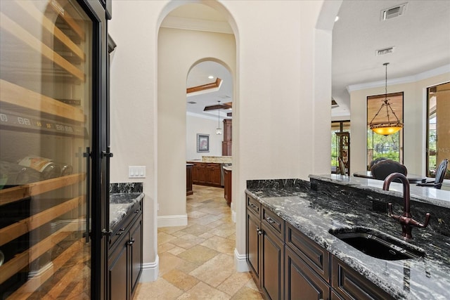 9253 Tibet Pointe Cir, Windermere, FL 34786 - bar with a sink, stone tile flooring, ornamental molding, pendant lighting, and baseboards