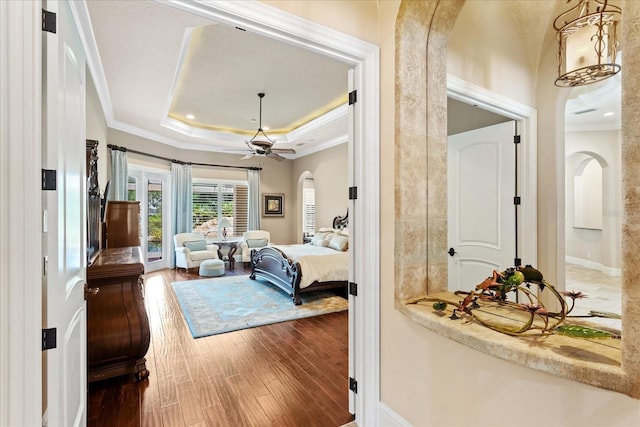 9253 Tibet Pointe Cir, Windermere, FL 34786 - bedroom with arched walkways, wood finished floors, a raised ceiling, ornamental molding, and baseboards