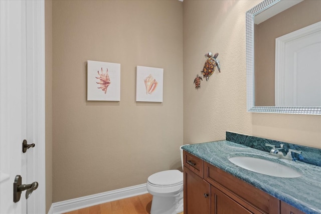 9253 Tibet Pointe Cir, Windermere, FL 34786 - half bathroom featuring vanity, toilet, baseboards, and wood finished floors