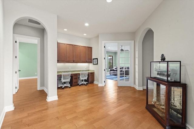 9253 Tibet Pointe Cir, Windermere, FL 34786 - kitchen with brown cabinets, light countertops, light wood-type flooring, recessed lighting, and arched walkways