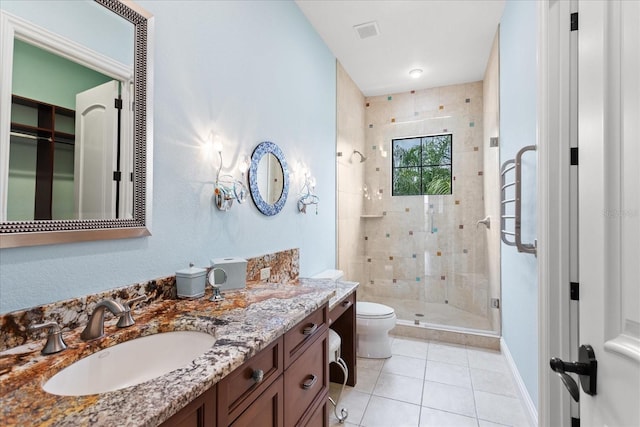 9253 Tibet Pointe Cir, Windermere, FL 34786 - bathroom with toilet, a shower stall, tile patterned flooring, double vanity, and baseboards