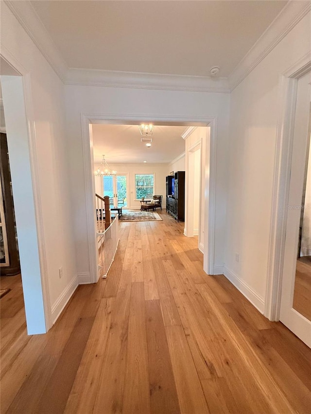 4309 W Beachway Dr, Tampa, FL 33609 - hallway with a chandelier, light wood finished floors, crown molding, and baseboards