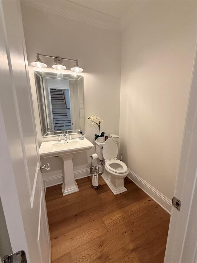 4309 W Beachway Dr, Tampa, FL 33609 - bathroom featuring toilet, wood finished floors, ornamental molding, and baseboards