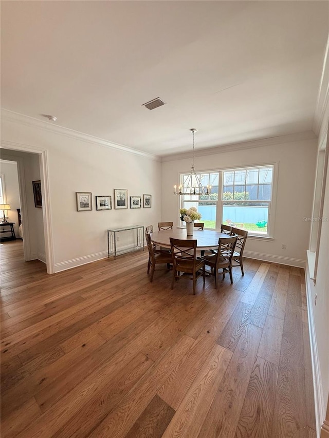 4309 W Beachway Dr, Tampa, FL 33609 - dining room featuring light wood-style floors, crown molding, a chandelier, and baseboards