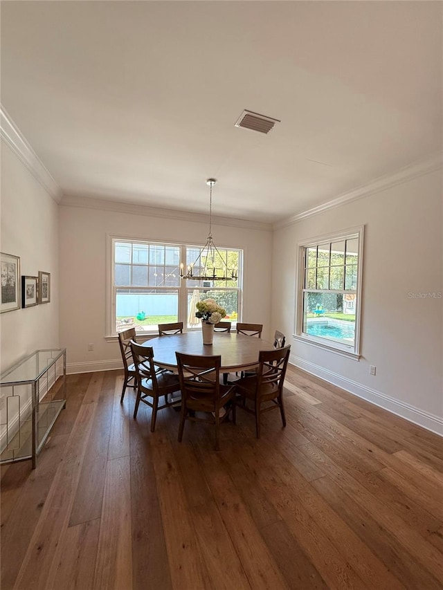 4309 W Beachway Dr, Tampa, FL 33609 - dining area featuring dark wood-style floors, a chandelier, baseboards, and ornamental molding