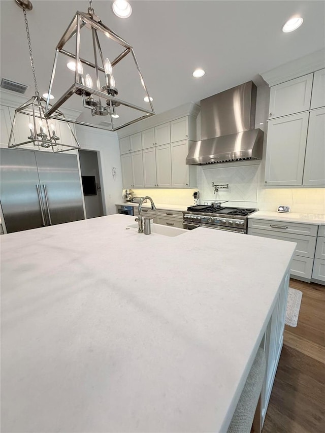 4309 W Beachway Dr, Tampa, FL 33609 - kitchen featuring wall chimney exhaust hood, high end appliances, a sink, a chandelier, and light countertops