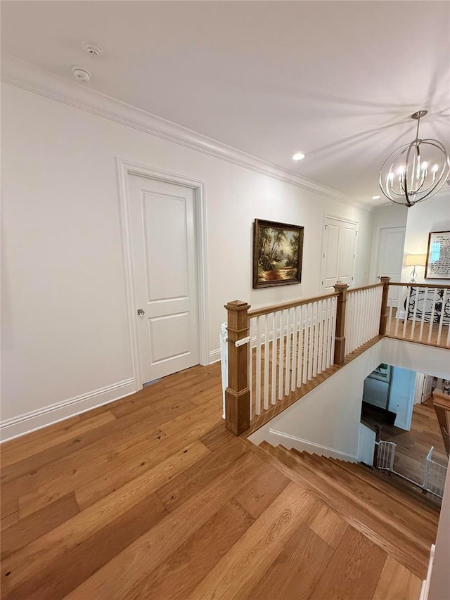 4309 W Beachway Dr, Tampa, FL 33609 - corridor with an upstairs landing, wood finished floors, crown molding, a chandelier, and recessed lighting