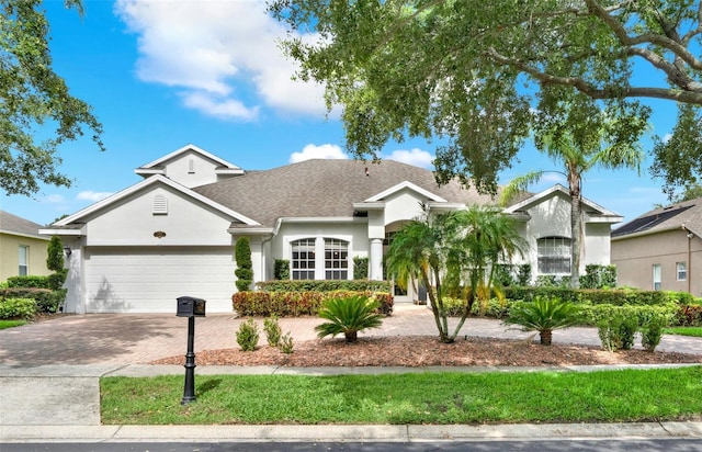 1932 Reed Hill Dr, Windermere, FL 34786 - view of front of house featuring stucco siding, decorative driveway, an attached garage, and a shingled roof
