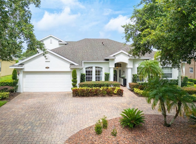1932 Reed Hill Dr, Windermere, FL 34786 - view of front of home featuring stucco siding, a shingled roof, a garage, and driveway