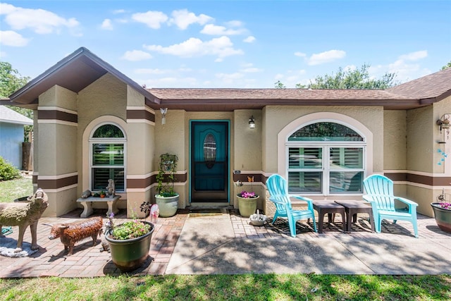 891 Licaria Dr, Ocoee, FL 34761 - property entrance with a patio, stucco siding, and a shingled roof