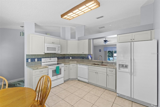 891 Licaria Dr, Ocoee, FL 34761 - kitchen featuring white appliances, tasteful backsplash, a textured ceiling, white cabinets, and light tile patterned floors