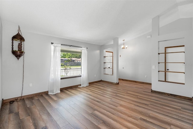6906 Sawmill Blvd, Ocoee, FL 34761 - empty room featuring vaulted ceiling, wood finished floors, a chandelier, and baseboards
