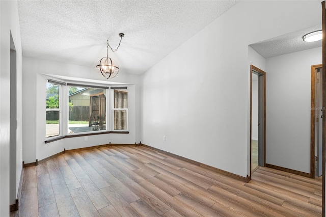 6906 Sawmill Blvd, Ocoee, FL 34761 - unfurnished room with a textured ceiling, wood finished floors, a chandelier, and baseboards