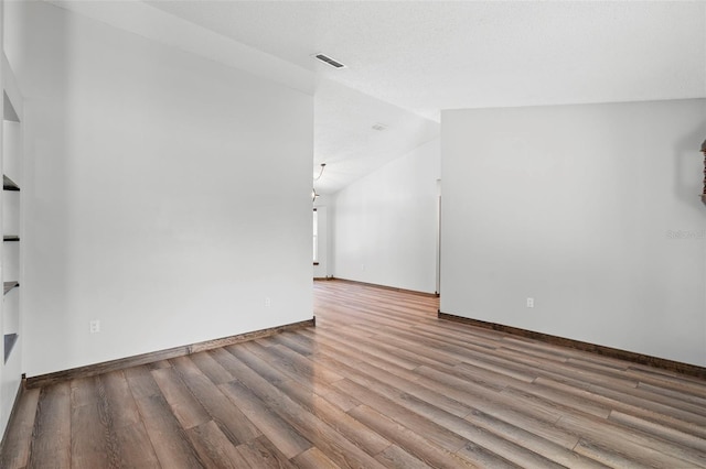 6906 Sawmill Blvd, Ocoee, FL 34761 - unfurnished living room with wood finished floors, vaulted ceiling, and baseboards