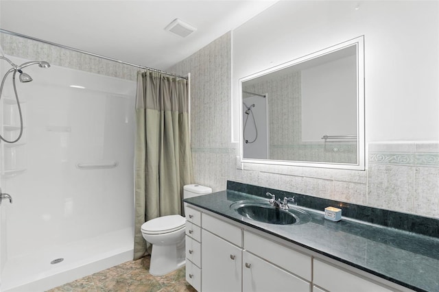 6906 Sawmill Blvd, Ocoee, FL 34761 - bathroom with tile walls, a shower with curtain, toilet, vanity, and a wainscoted wall