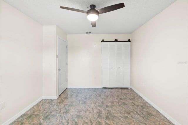 6906 Sawmill Blvd, Ocoee, FL 34761 - unfurnished bedroom featuring a barn door, baseboards, and ceiling fan