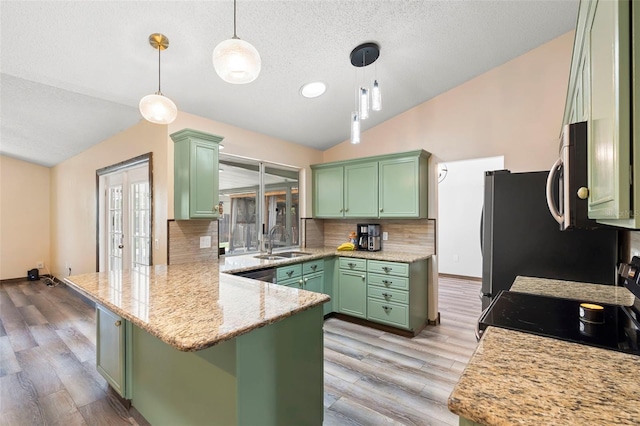 6906 Sawmill Blvd, Ocoee, FL 34761 - kitchen featuring green cabinetry, a sink, vaulted ceiling, a peninsula, and tasteful backsplash