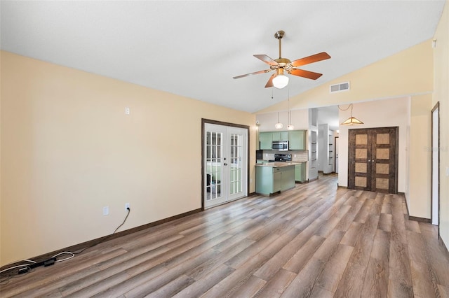 6906 Sawmill Blvd, Ocoee, FL 34761 - unfurnished living room featuring french doors, light wood-style floors, a ceiling fan, baseboards, and high vaulted ceiling