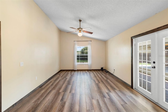 6906 Sawmill Blvd, Ocoee, FL 34761 - unfurnished room with vaulted ceiling, a textured ceiling, wood finished floors, a ceiling fan, and french doors