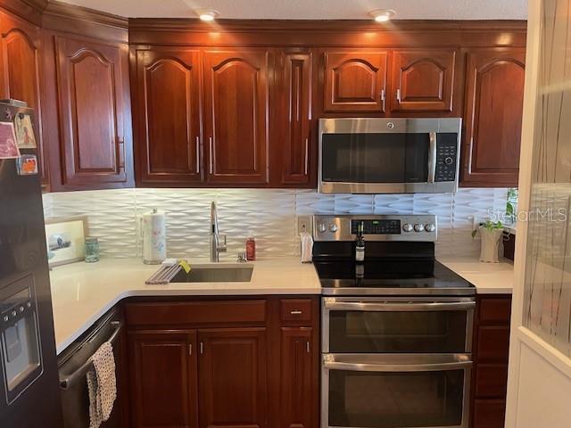400 E Colonial Dr Unit 910, Orlando, FL 32803 - kitchen featuring appliances with stainless steel finishes, a sink, and light countertops