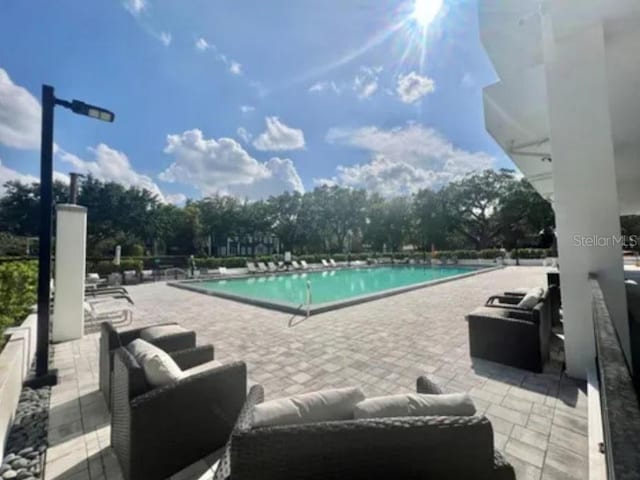 400 E Colonial Dr Unit 910, Orlando, FL 32803 - community pool featuring a patio and an outdoor hangout area